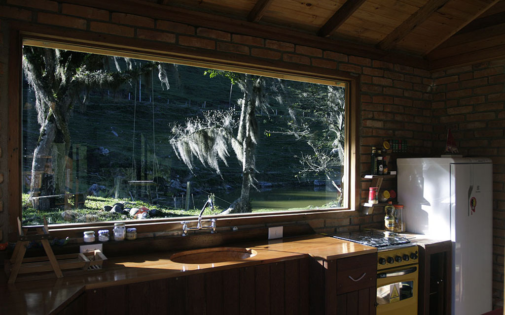 Cozinha interna com com vista para a área da cozinha externa da Casinha , a maior entre as três Casas da Pousada Pedras Rollantes, em Alfredo Wagner